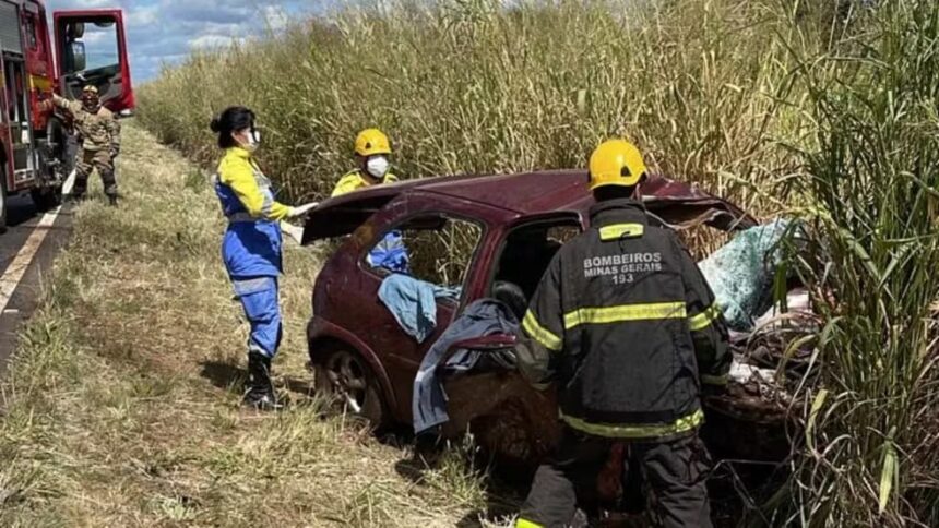 Bombeiros resgatam vítima em carro destruído após colisão frontal na MGC-497, em Uberlândia, com veículo fora da pista em área de vegetação